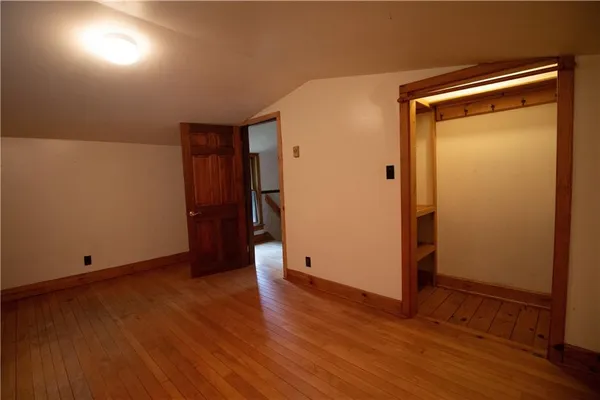 an empty room with wooden floor and closet