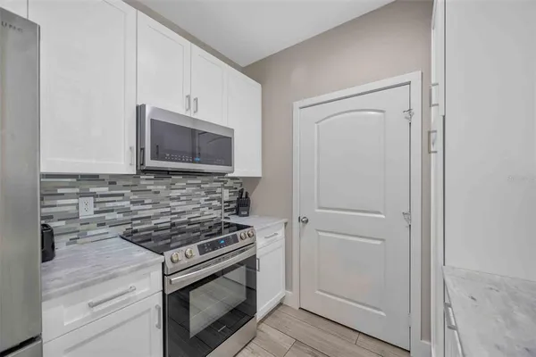a kitchen with cabinets stainless steel appliances and wooden floor