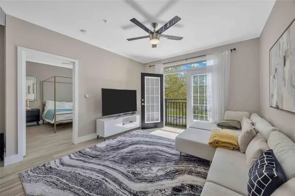 a living room with furniture a ceiling fan and a flat screen tv