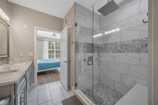 a bathroom with a granite countertop sink a toilet and shower