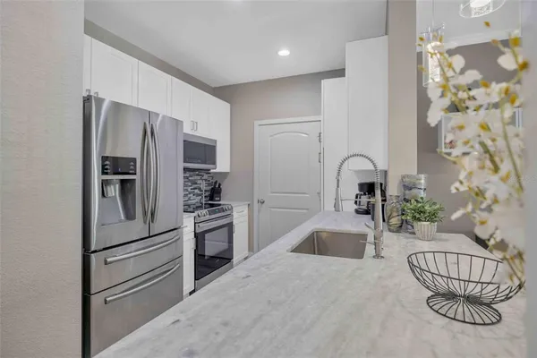 a kitchen with granite countertop stainless steel appliances a refrigerator and a sink