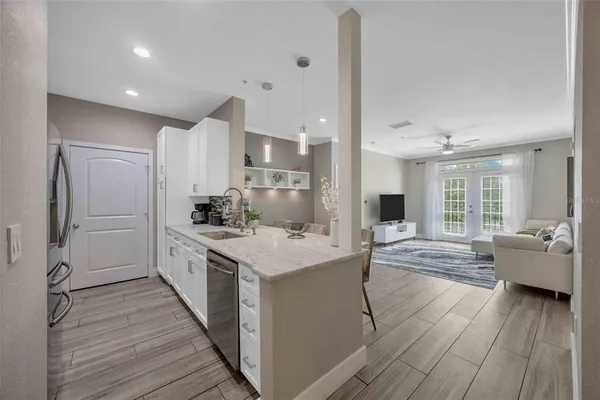 a large kitchen with kitchen island white cabinets and stainless steel appliances