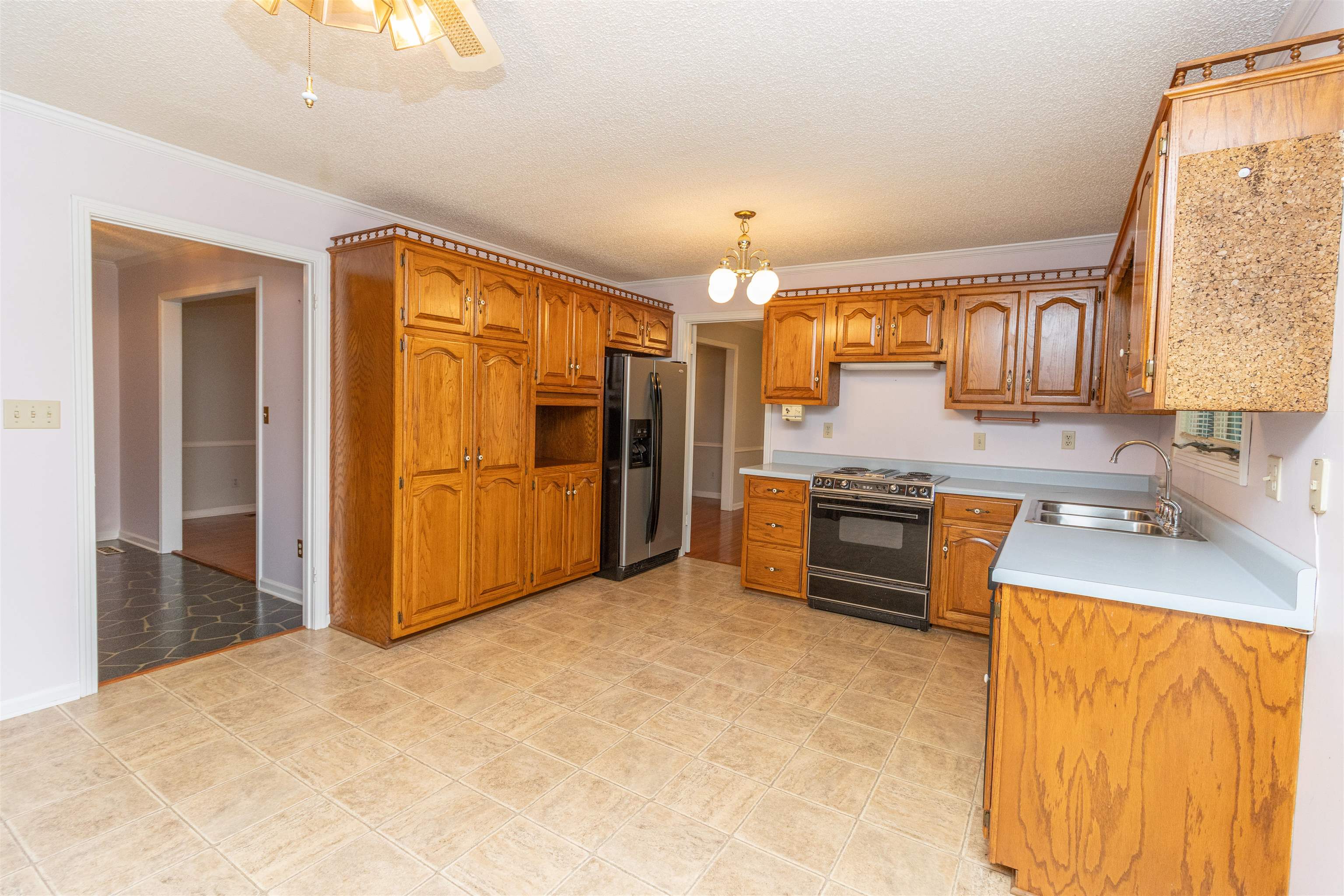 651 Pine Street Adamsville, TN 38310 - Photo 11 of 25 a kitchen with stainless steel appliances granite countertop a refrigerator and a stove top oven