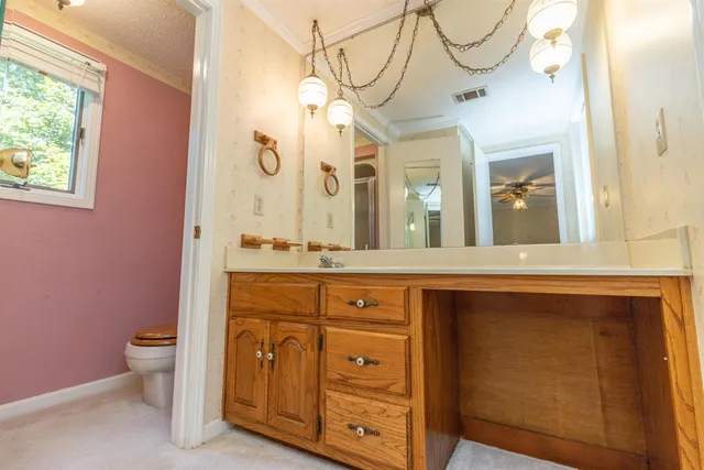 a spacious bathroom with a granite countertop sink a toilet and a mirror