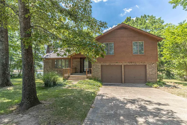 a front view of a house with a yard and trees