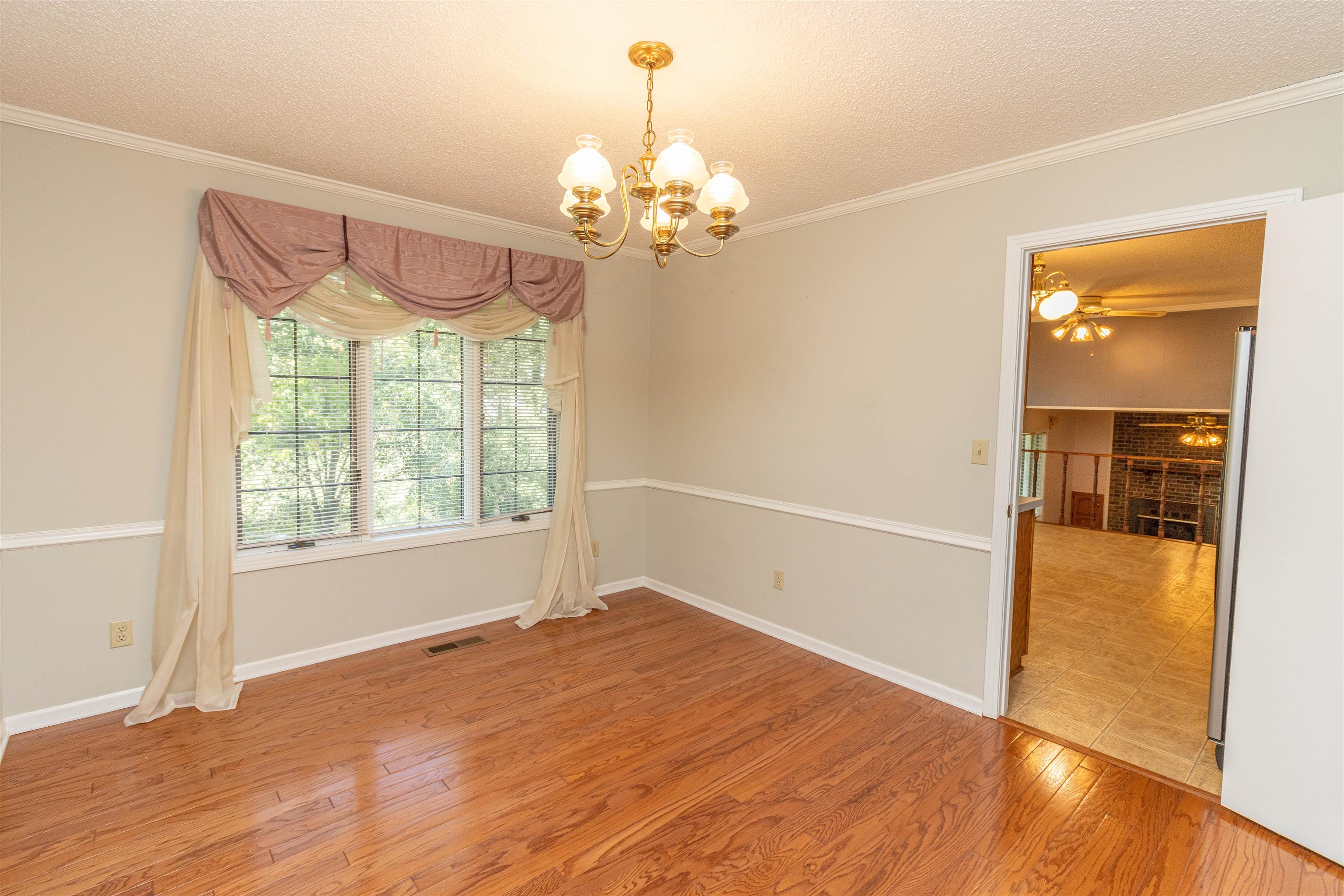651 Pine Street Adamsville, TN 38310 - Photo 7 of 25 wooden floor in an empty room with a window