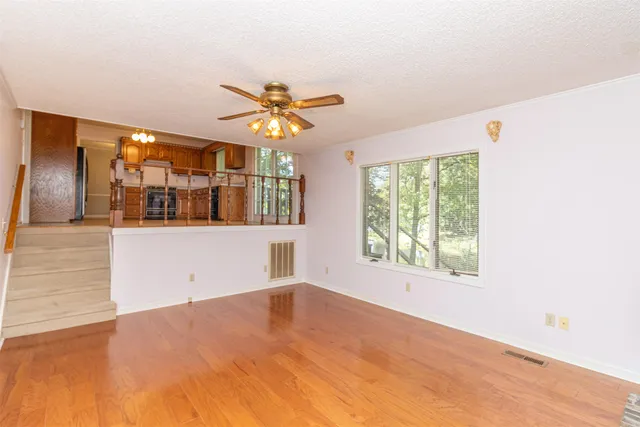 a view of a big room with wooden floor and windows