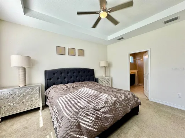 a bedroom with a bed and a lamp on a dresser