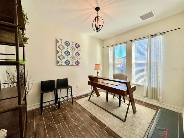 a view of a workspace with furniture window and wooden floor