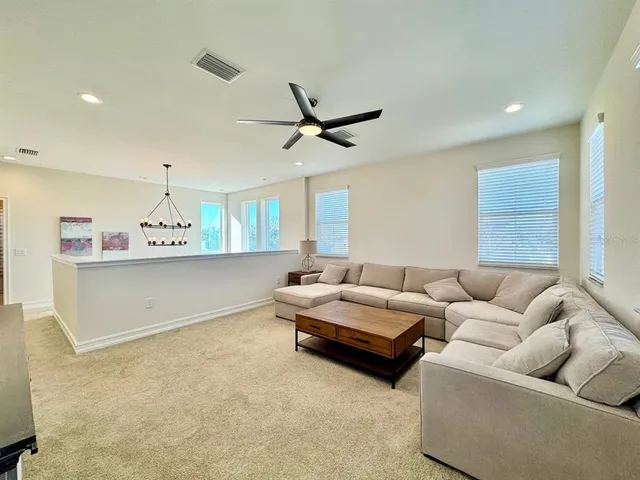a living room with furniture and a ceiling fan