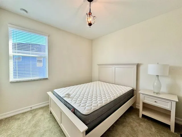 a bed sitting in a bedroom next to a window