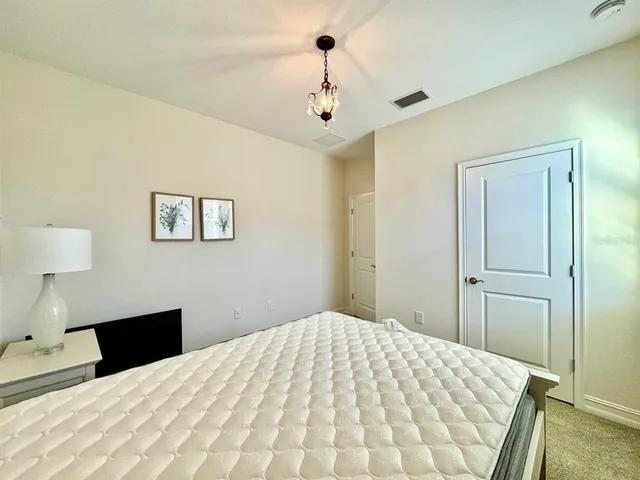 a bedroom with a bed and a chandelier
