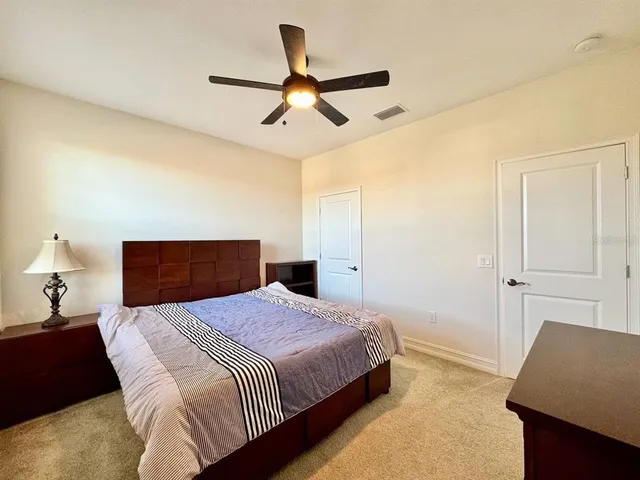 a bedroom with a bed and a lamp with the wooden floor