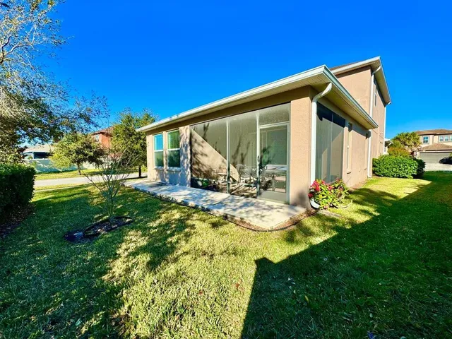 a view of a house with backyard and sitting area