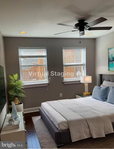 a bedroom with a bed potted plant on table and a window