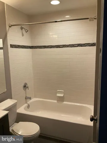 a bathroom with a shower a toilet and a tub