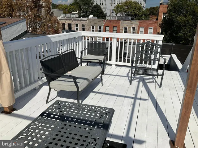 a view of a roof deck with table and chairs
