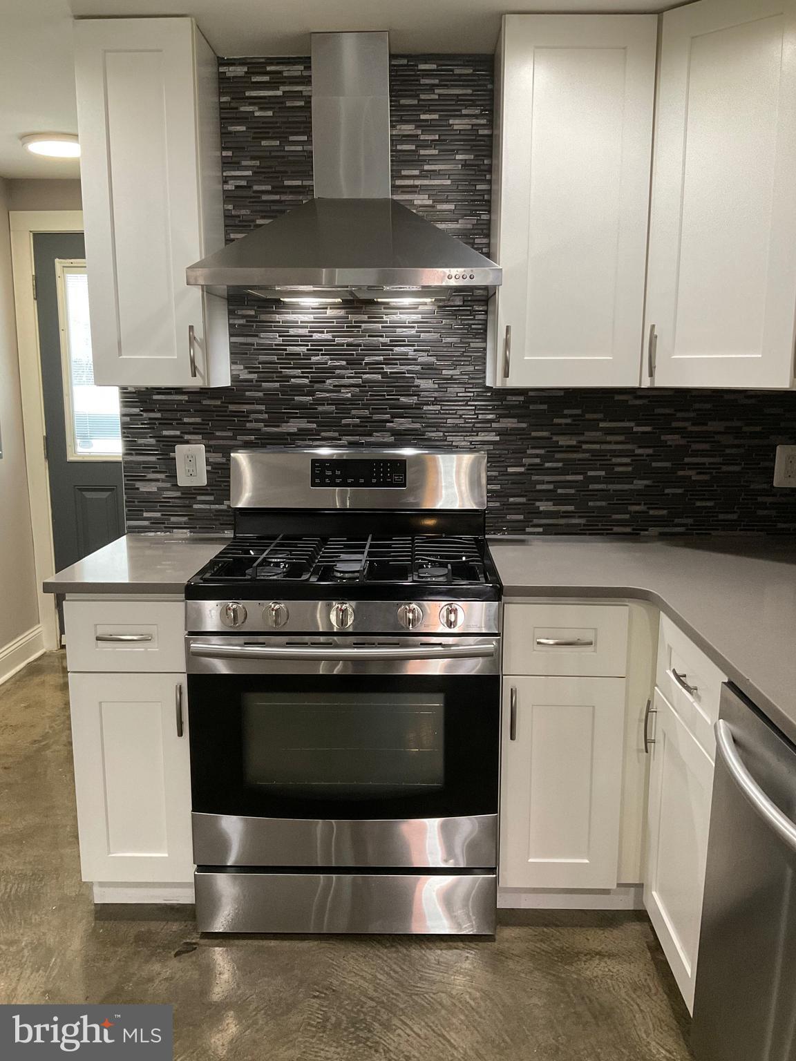 2437 Fleet Street Baltimore, MD 21224 - Photo 6 of 33 a kitchen with granite countertop white cabinets and white appliances