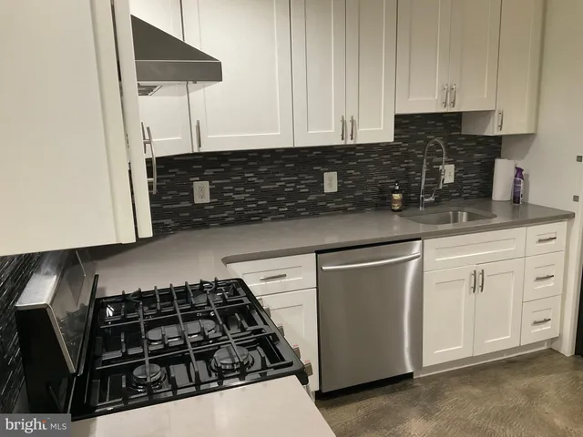 a kitchen with white cabinets and appliances