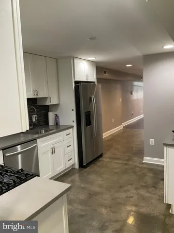 a kitchen with granite countertop a refrigerator and a stove top oven