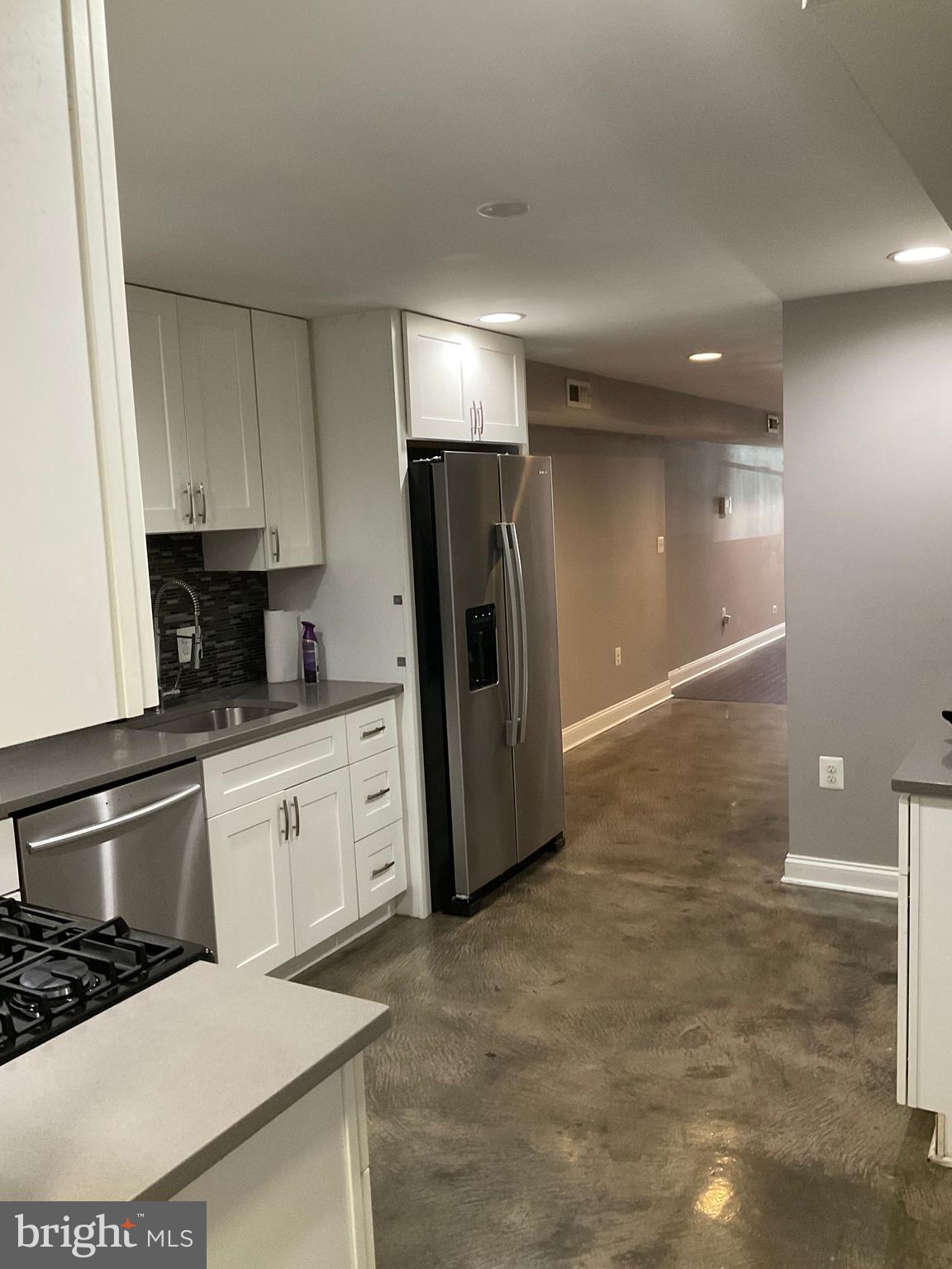 2437 Fleet Street Baltimore, MD 21224 - Photo 10 of 33 a kitchen with granite countertop a refrigerator and a stove top oven