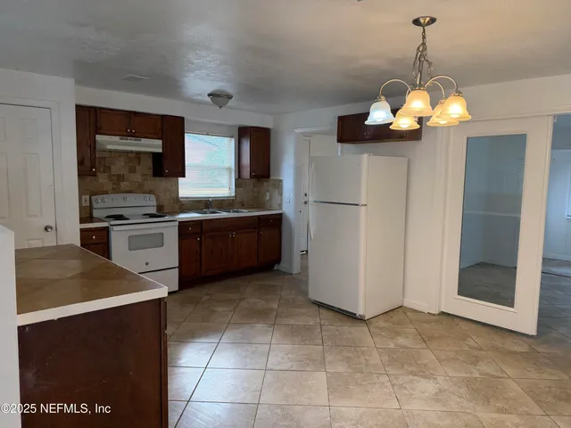a kitchen with stainless steel appliances granite countertop a sink a stove and a refrigerator