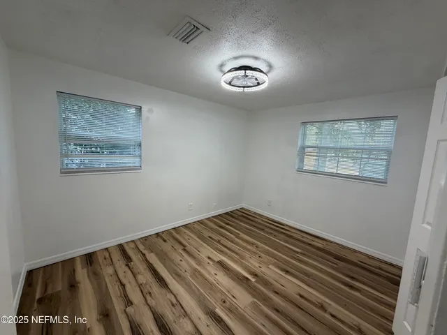 a view of a room with wooden floor