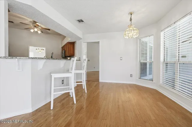 a view of empty room with wooden floor and window