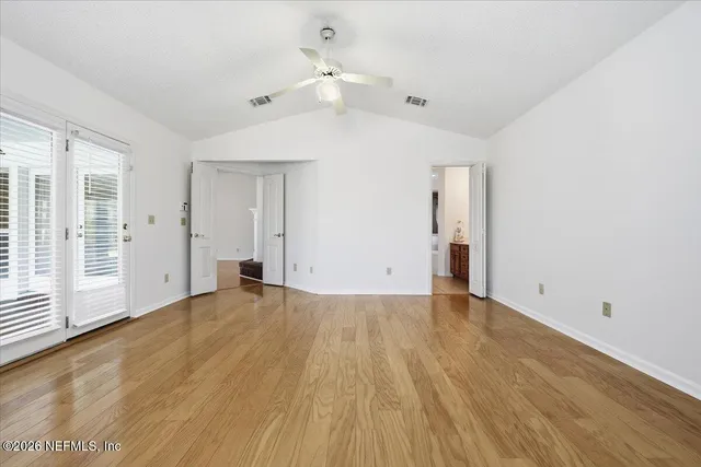 an empty room with wooden floor and windows