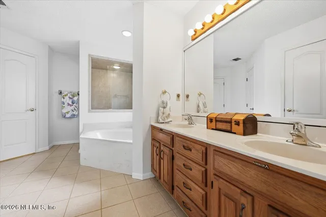 a spacious bathroom with a granite countertop sink and a mirror