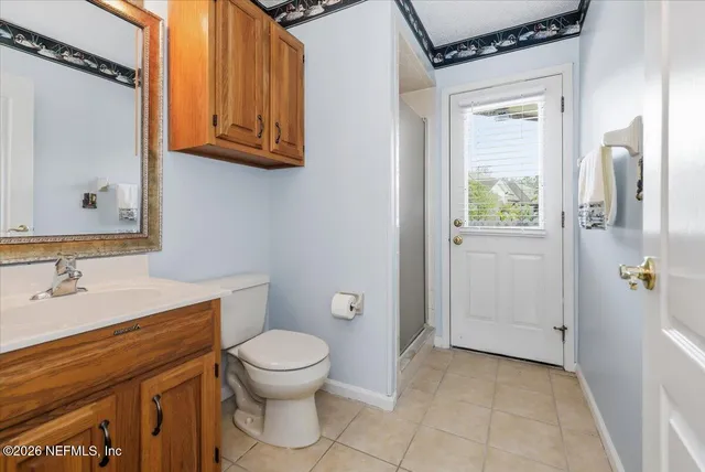 a bathroom with a granite countertop toilet sink and mirror