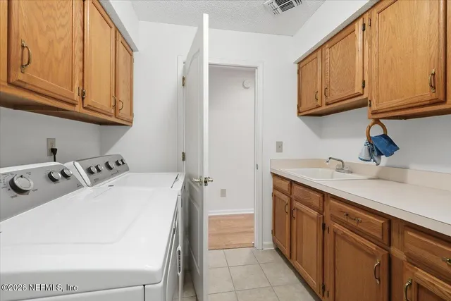 a utility room with sink dryer and washer