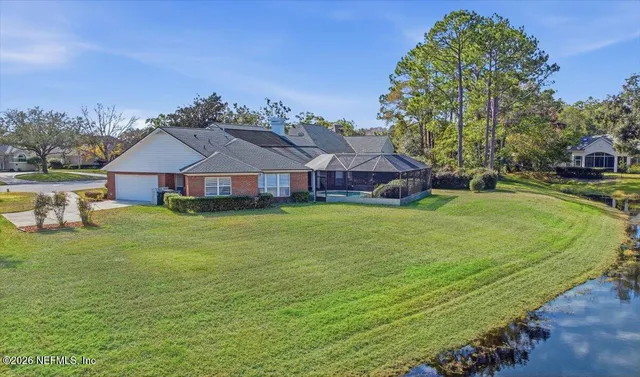 a aerial view of a house with a big yard and large trees
