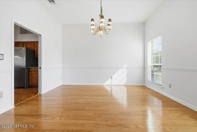 a view of wooden floor and a chandelier in a room
