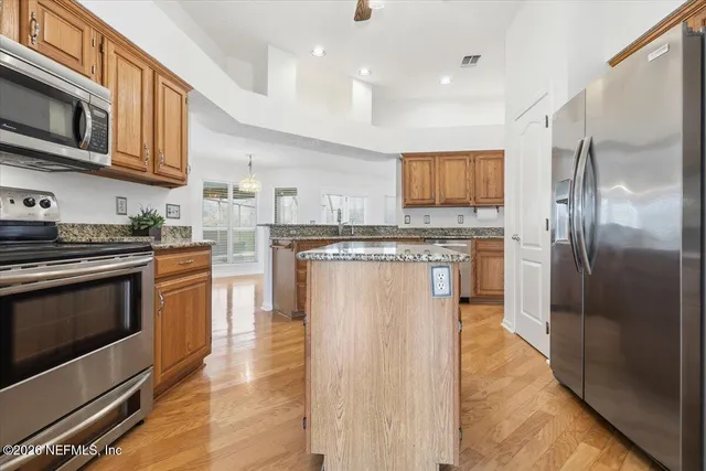 a kitchen with stainless steel appliances granite countertop a refrigerator a stove top oven a sink and dishwasher