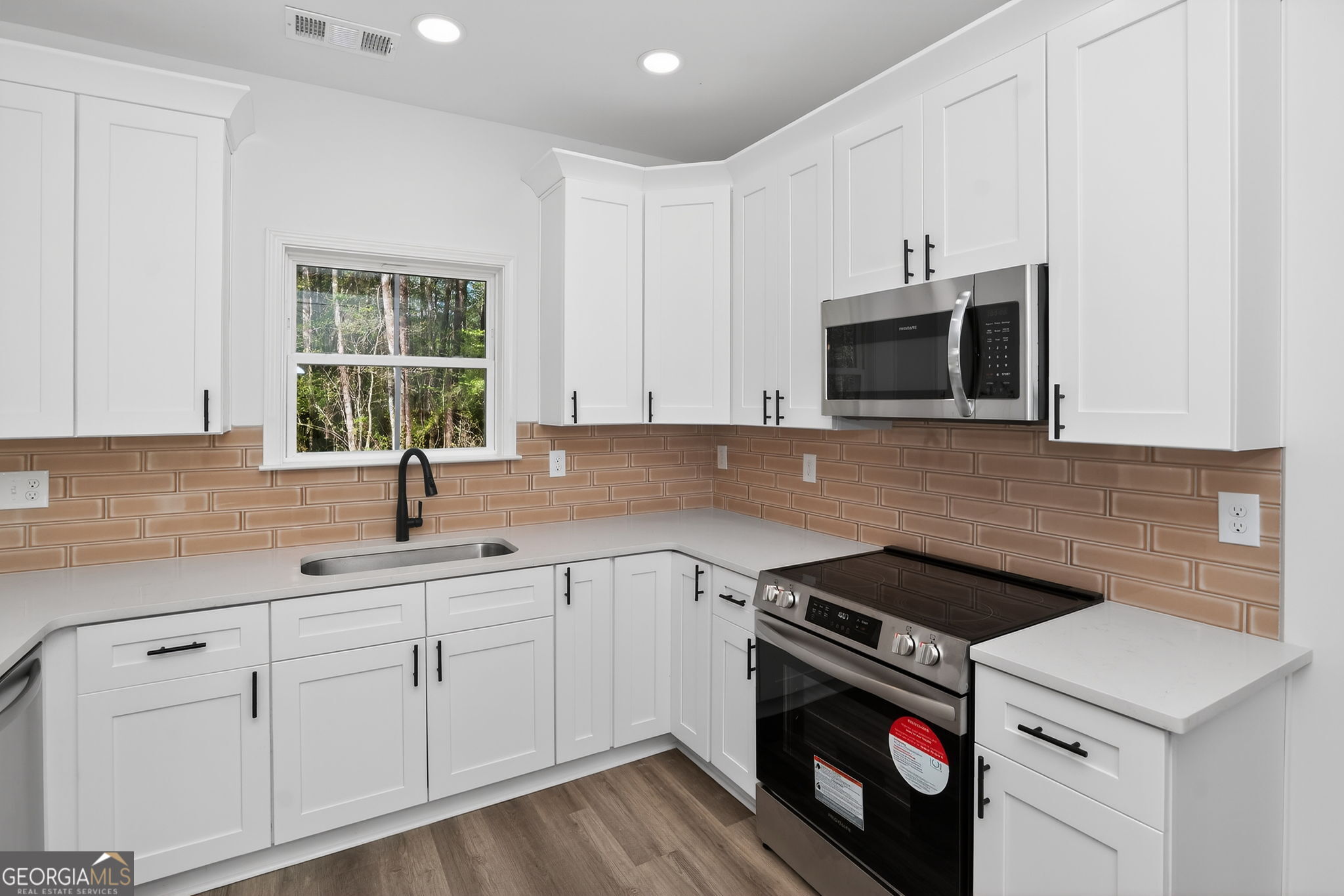 1229 Chappell Mill Road Jackson, GA 30233 - Photo 27 of 55 a kitchen with white cabinets stainless steel appliances and sink