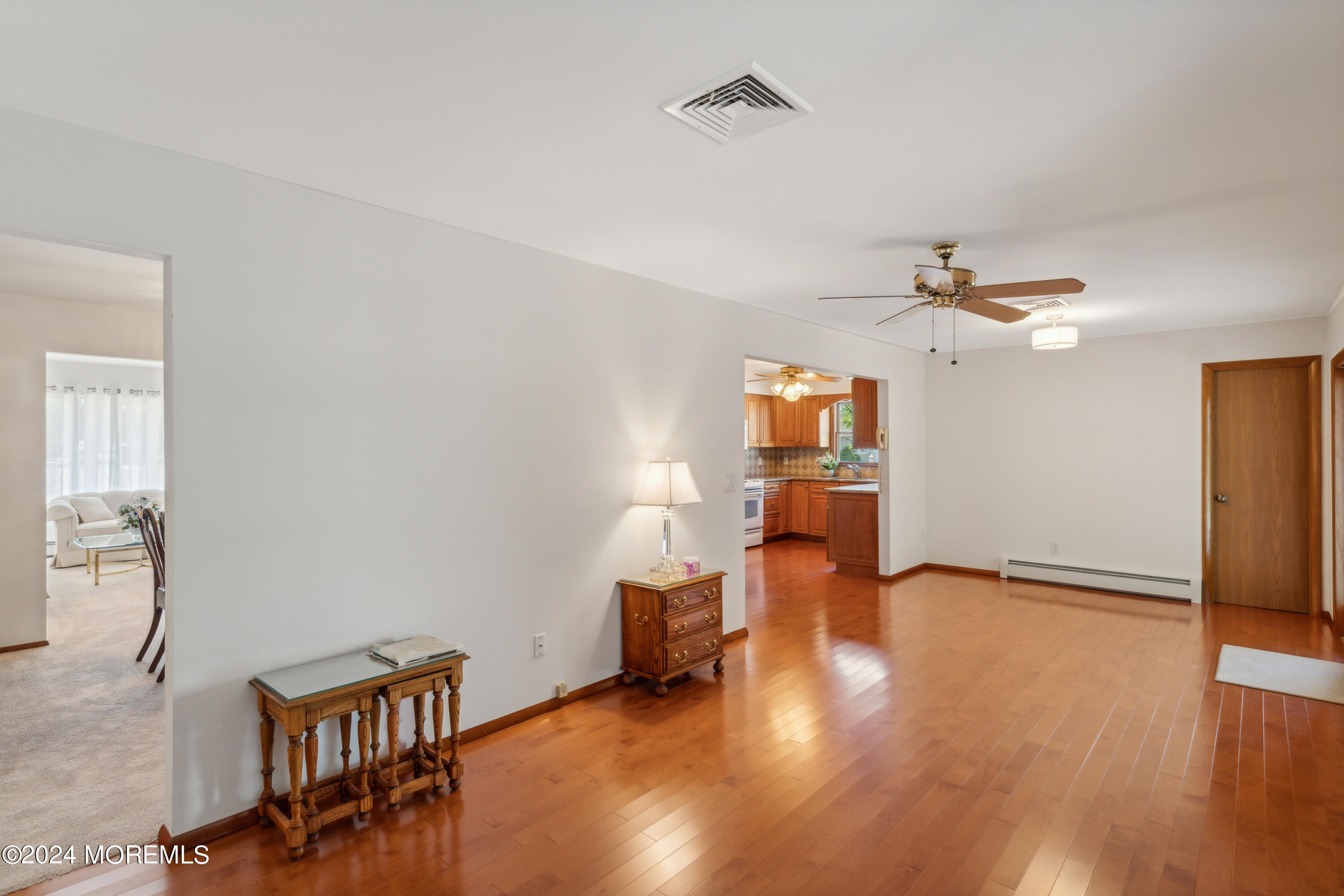 3 Garrett Road Toms River, NJ 08757 - Photo 12 of 24 a view of a livingroom with wooden floor and a ceiling fan