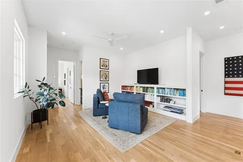 a living room with furniture potted plant and flat screen tv