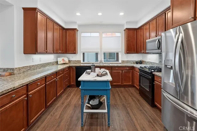 a kitchen with wooden cabinets sink and stainless steel appliances