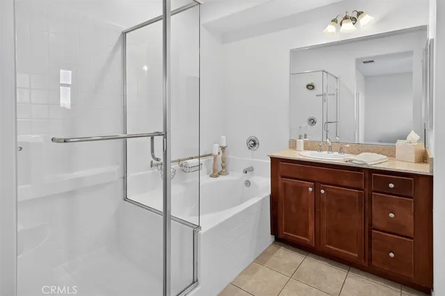 a bathroom with a bathtub sink vanity granite and a mirror