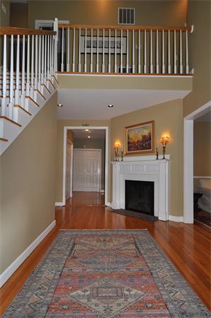 67 Brook Street Wellesley, MA 02482 - Photo 9 of 14 a view of an empty room with wooden floor a fireplace and a window
