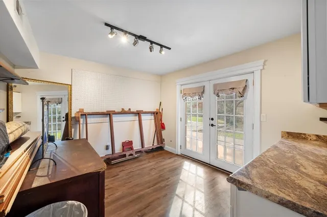 a view of a kitchen with wooden floor and cabinets