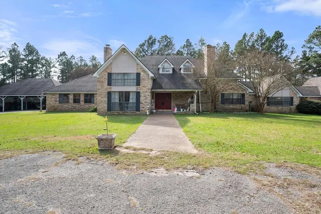 a aerial view of a house with a yard and trees