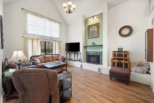 a living room with furniture a clock on wall and a large window