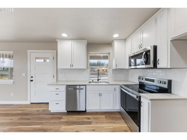 a kitchen with stainless steel appliances granite countertop a stove a sink and a microwave