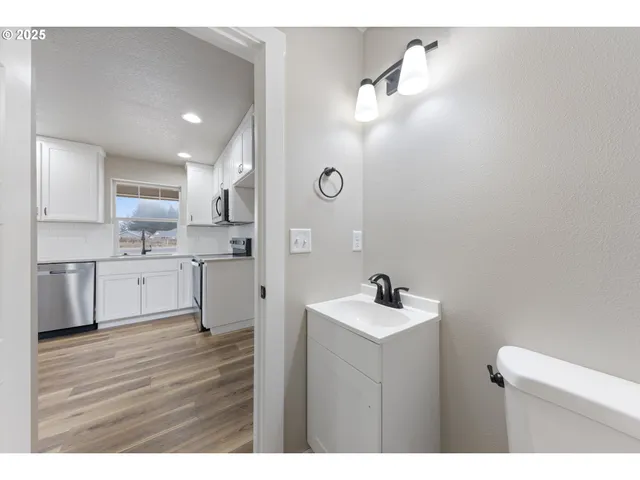a kitchen with a sink cabinets and wooden floor