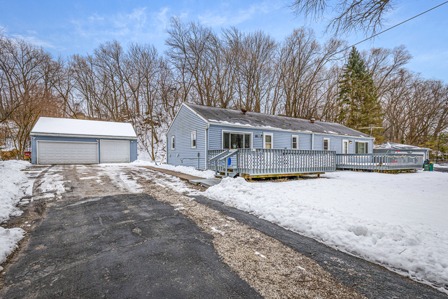 a front view of a house with a yard and covered with snow