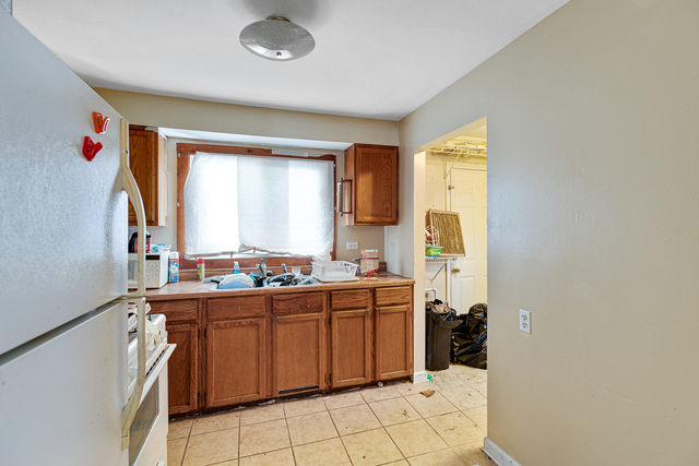81-83 Eagle Point Road Fox Lake, IL 60020 - Photo 14 of 23 a kitchen with a sink a stove cabinets and a window