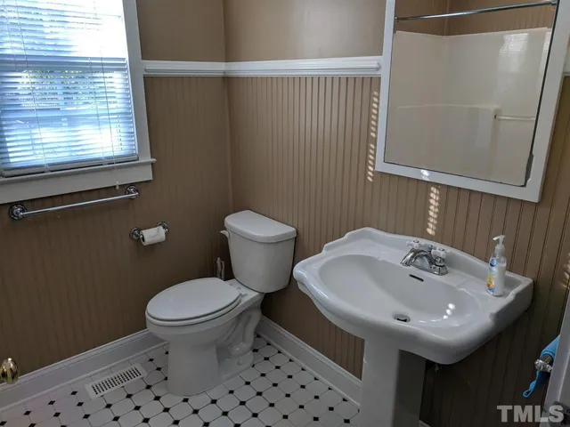 a bathroom with a sink a toilet and a mirror