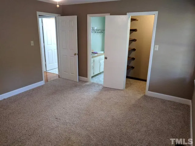 an empty room with closet and wooden door
